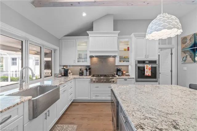 a large kitchen with stainless steel appliances granite countertop a sink stove and refrigerator