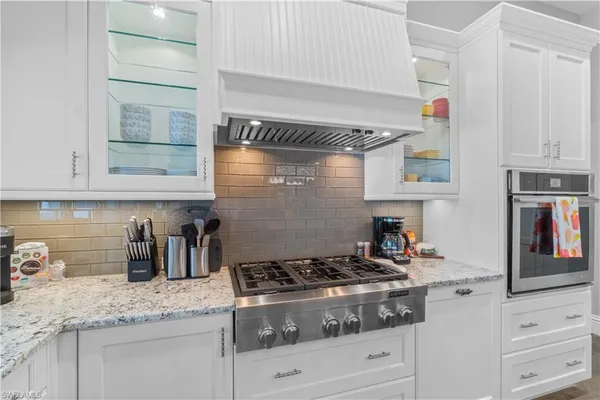 a kitchen with granite countertop stainless steel appliances stove and cabinets