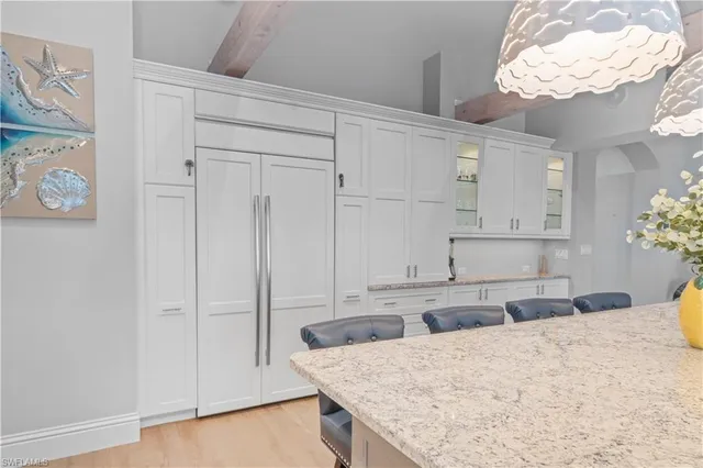 a kitchen with granite countertop cabinets and chandelier