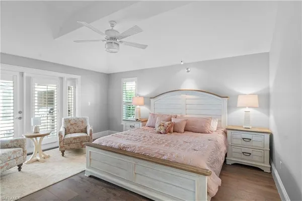 a bedroom with a large bed and windows