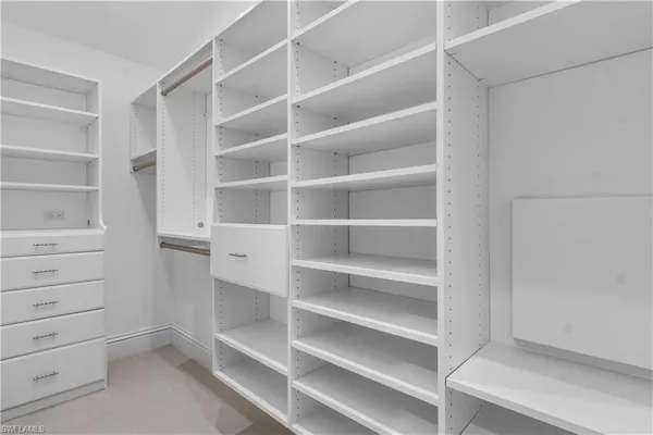 a view of walk in closet with empty racks