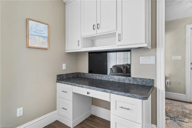 a kitchen with granite countertop white cabinets and sink
