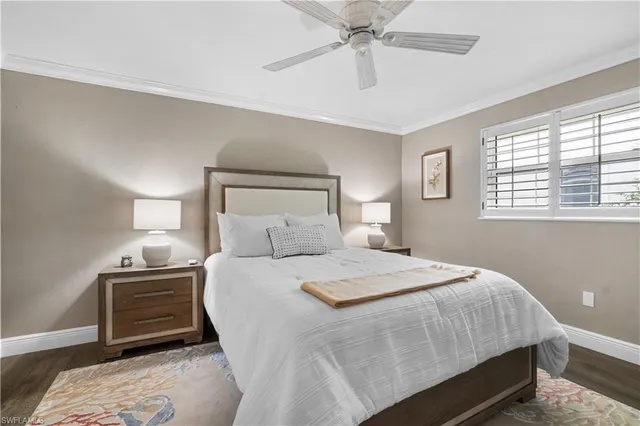 a bedroom with a bed a chandelier and a window