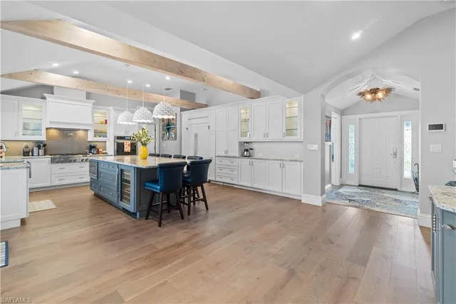 a large white kitchen with lots of counter space and dining table