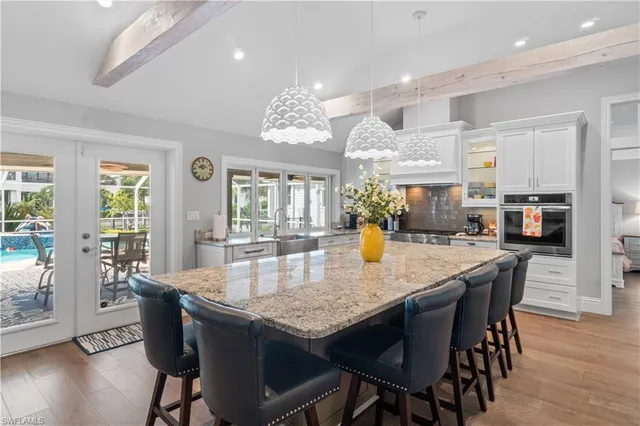a view of a dining room and livingroom with furniture wooden floor a chandelier