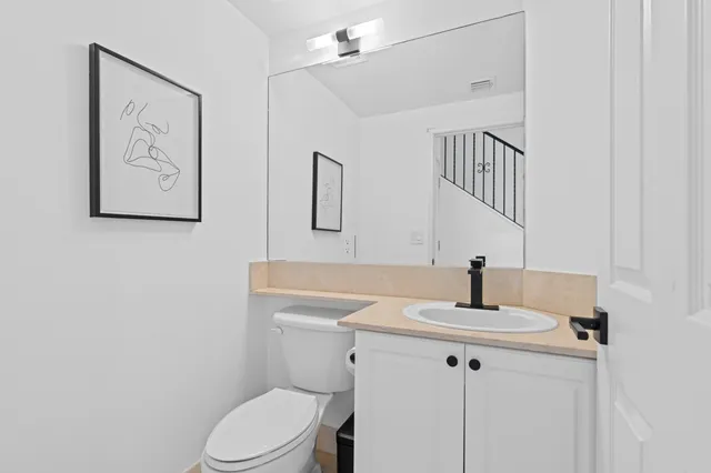 a bathroom with a toilet sink and mirror