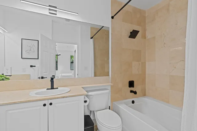 a bathroom with a sink a toilet a mirror a bathtub and shower