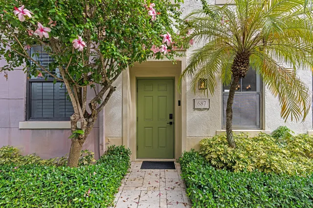 a front view of a house with a tree
