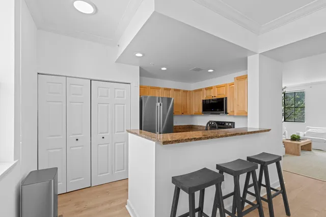 a kitchen with stainless steel appliances granite countertop a stove a sink and a refrigerator