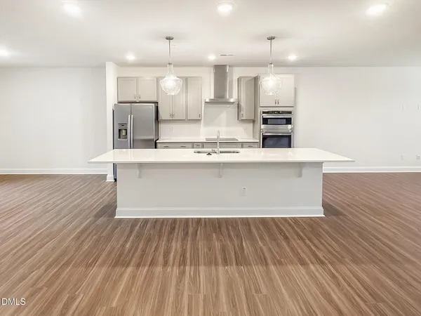 a kitchen with stainless steel appliances a dining table chairs stove and cabinets