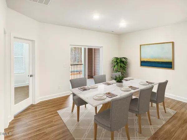 an empty room with wooden floor & windows