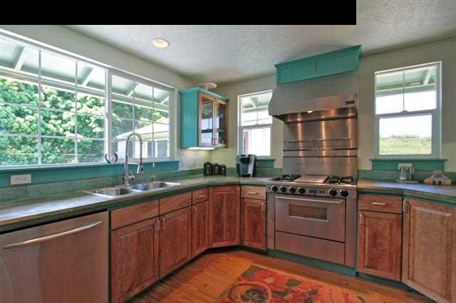 260 Awalau Road Haiku, HI 96708 - Photo 6 of 30 a kitchen with stainless steel appliances granite countertop wooden cabinets stove top oven and sink
