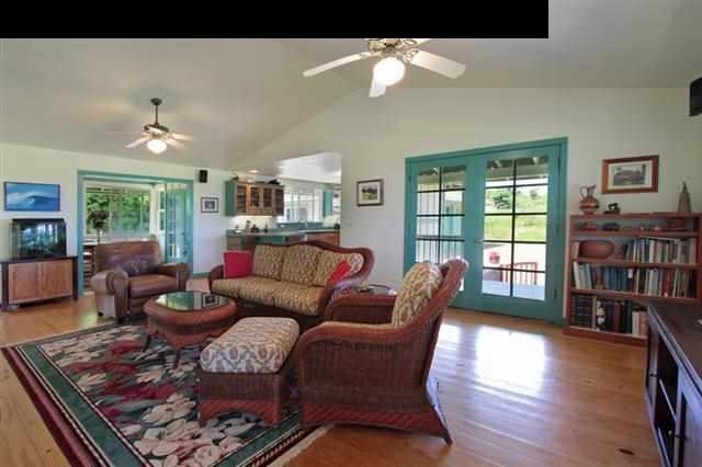 260 Awalau Road Haiku, HI 96708 - Photo 7 of 30 a living room with furniture a bookshelf and a large window
