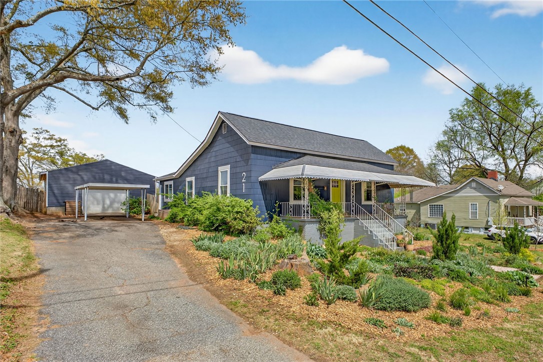 This charming home features a lovely front porch and a lush garden.