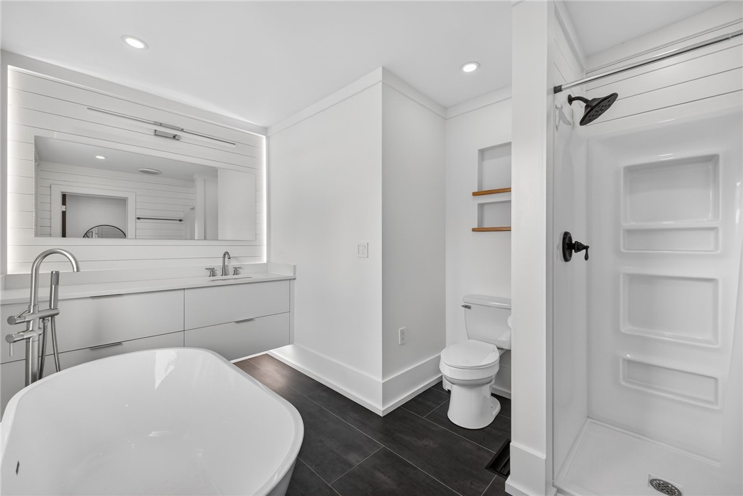 21 Haynes Street Piedmont, SC 29673 - Photo 12 of 35 This bright bathroom features a luxurious soaking tub, spacious vanity, and modern shower, creating a serene retreat.