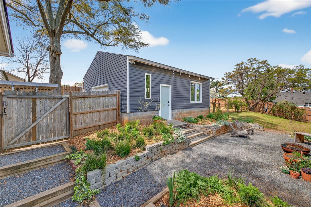21 Haynes Street Piedmont, SC 29673 - Photo 20 of 35 This private backyard features a detached structure, gravel pathways, and terraced landscaping.