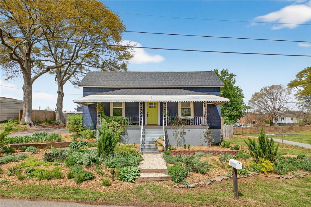 21 Haynes Street Piedmont, SC 29673 - Photo 3 of 35 This charming home features a welcoming porch, lush garden, and classic architecture.