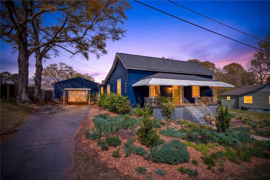 21 Haynes Street Piedmont, SC 29673 - Photo 4 of 35 This captivating home boasts a well-maintained exterior and inviting front porch, perfect for enjoying twilight evenings.