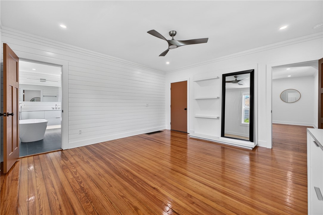 21 Haynes Street Piedmont, SC 29673 - Photo 9 of 35 This primary bedroom features elegant wood flooring, crisp white walls, and a modern ceiling fan.