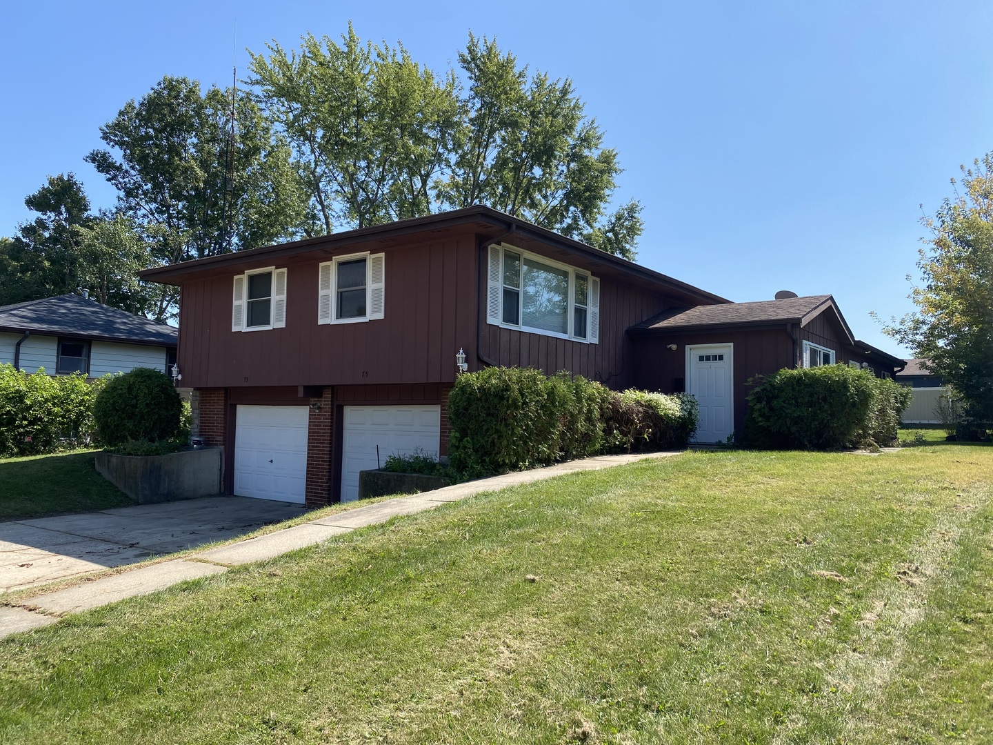 73-75 Neil Road Sugar Grove, IL 60554 - Photo 3 of 4 a front view of a house with a garden