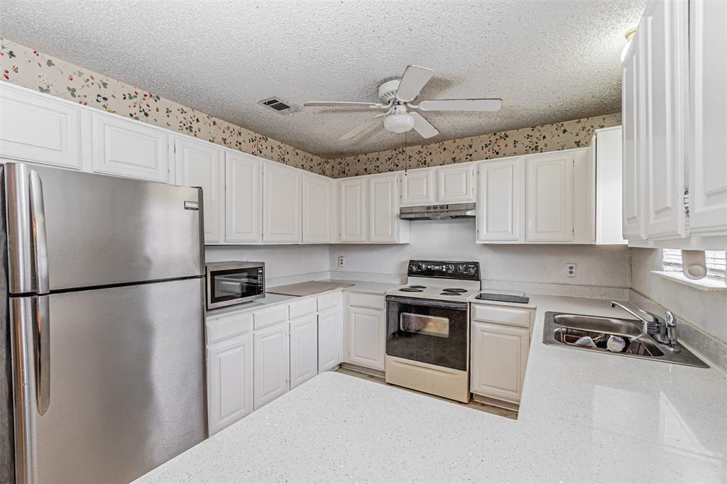 108 Cole Road Red Oak, TX 75154 - Photo 17 of 30 a kitchen with stainless steel appliances a refrigerator a stove a sink and white cabinets