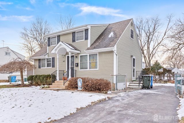a front view of a house with a yard covered with snow