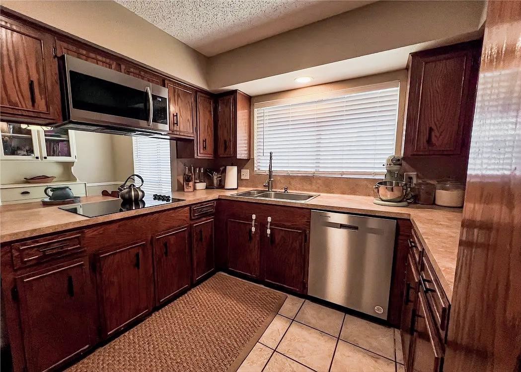 418 Seco Drive Portland, TX 78374 - Photo 12 of 32 a kitchen with stainless steel appliances granite countertop a sink stove and microwave
