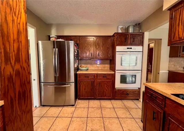 a kitchen with stainless steel appliances granite countertop a refrigerator and a sink