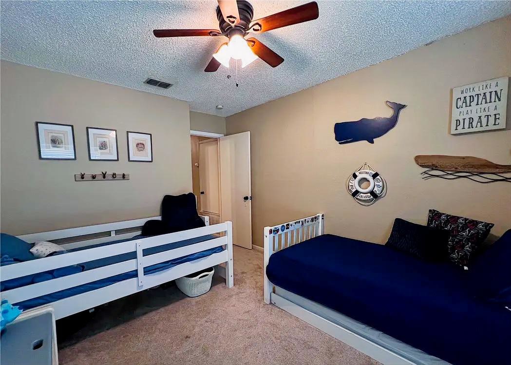 418 Seco Drive Portland, TX 78374 - Photo 19 of 32 a bedroom with a bed and a chandelier