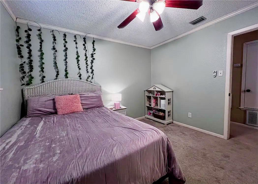 418 Seco Drive Portland, TX 78374 - Photo 21 of 32 a bedroom with a large bed and a chandelier
