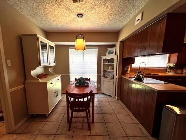 a kitchen with stainless steel appliances kitchen island granite countertop a sink and a refrigerator