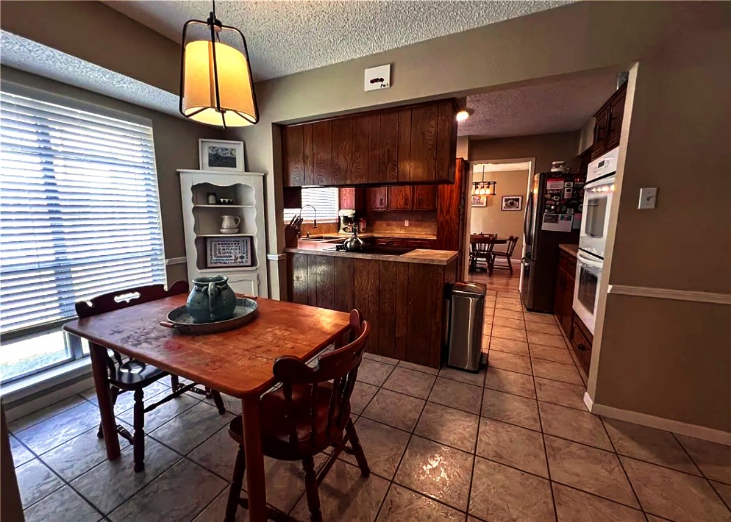 418 Seco Drive Portland, TX 78374 - Photo 9 of 32 a kitchen with stainless steel appliances kitchen island granite countertop a table chairs and a refrigerator