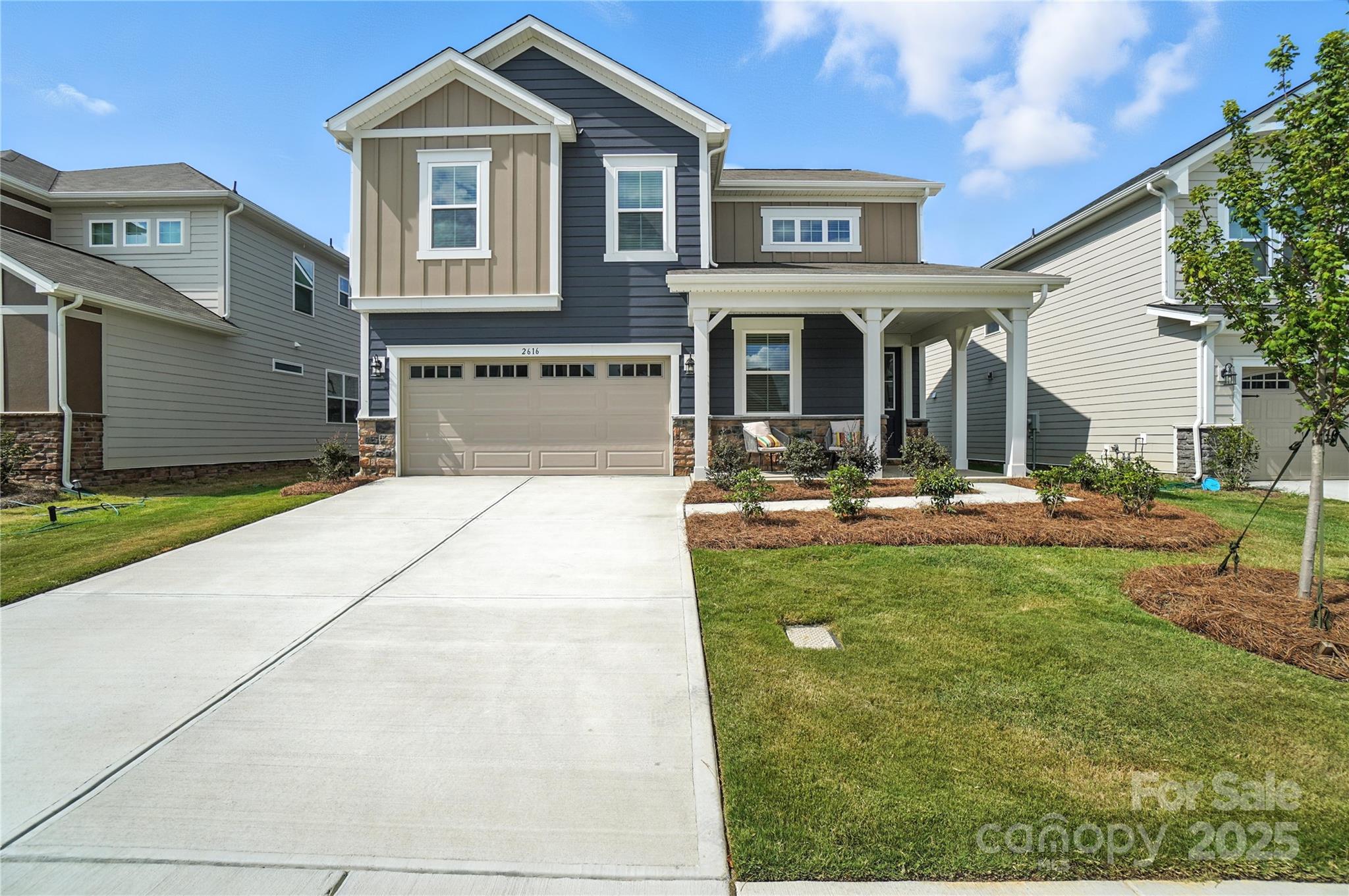 a view of a brick house with many windows yard and a tree
