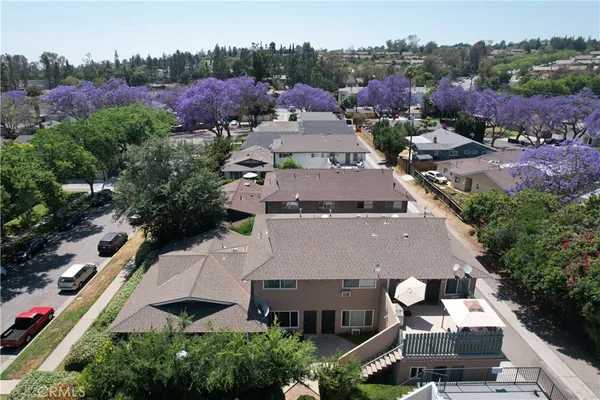 an aerial view of multiple houses with a yard