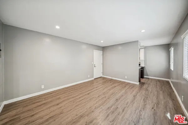a view of an empty room with wooden floor