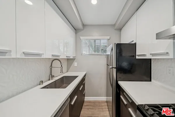 a kitchen that has a refrigerator a sink and a stove