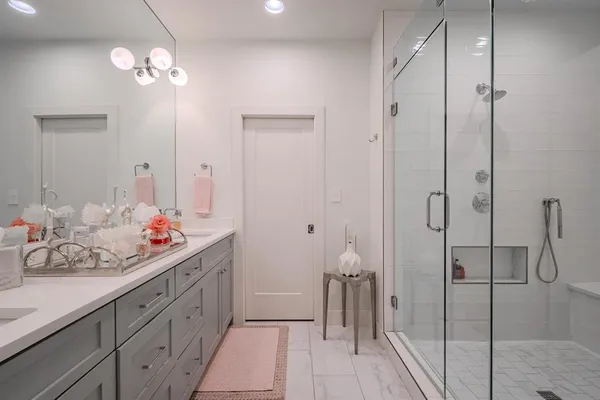 a bathroom with a double vanity sink mirror and shower