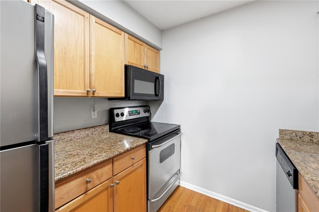 1150 Collier Road Northwest, Unit 4C Atlanta, GA 30318 - Photo 11 of 27 a kitchen with granite countertop cabinets stainless steel appliances and a window