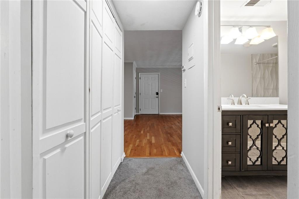 1150 Collier Road Northwest, Unit 4C Atlanta, GA 30318 - Photo 15 of 27 a view of a hallway with wooden floor and a bathroom