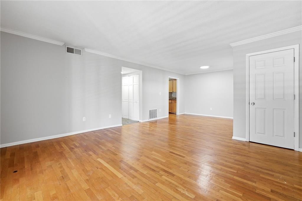 1150 Collier Road Northwest, Unit 4C Atlanta, GA 30318 - Photo 5 of 27 a view of an empty room with wooden floor and a window