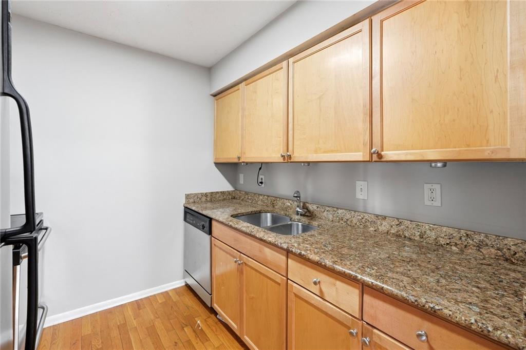 1150 Collier Road Northwest, Unit 4C Atlanta, GA 30318 - Photo 10 of 27 a kitchen with granite countertop white cabinets and sink