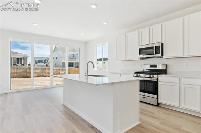 a kitchen with stainless steel appliances kitchen island wooden cabinets and a stove top oven