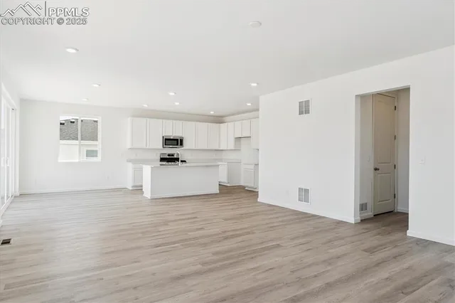 a view of kitchen with wooden floor and electronic appliances