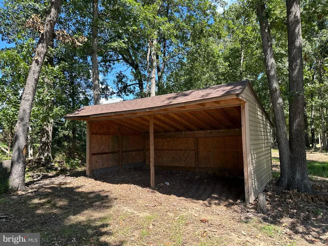 an empty room with wooden floor fireplace and windows