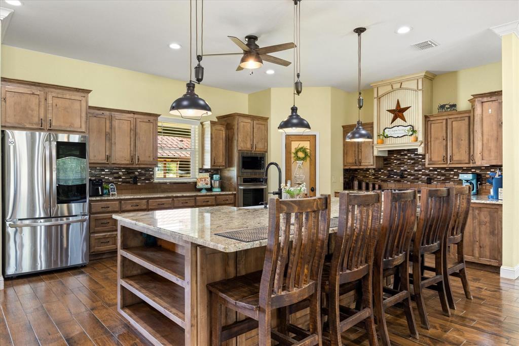 9739 Waldrup Road Lipan, TX 76462 - Photo 10 of 38 Not only is the island oversized, but the space between the island and back cabinets is also oversized, insuring there's room for everyone to help in the kitchen.