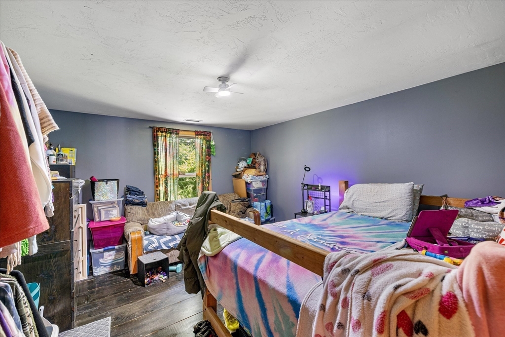 8 Oakwood Road Brimfield, MA 01010 - Photo 12 of 34 a bedroom with a bed a standing fan and a bookshelf