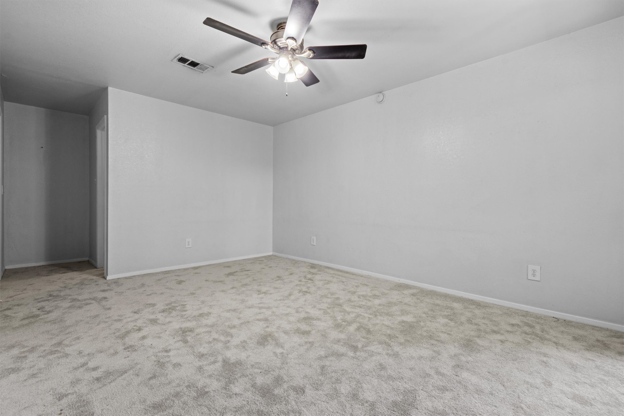3627 Menchaca Road, Unit 204 Austin, TX 78704 - Photo 18 of 23 A spacious room features soft gray carpeting and a practical ceiling fan for year-round comfort.
