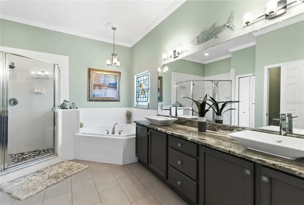a spacious bathroom with a granite countertop double vanity sink a mirror and a bathtub