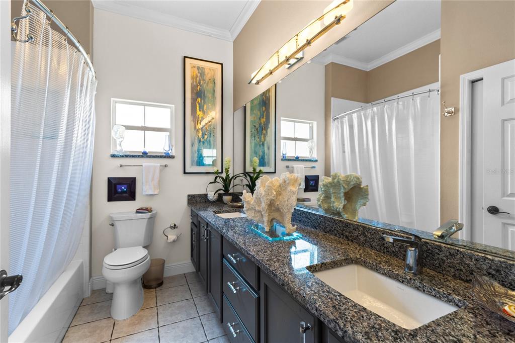 4846 Calasans Avenue St. Cloud, FL 34771 - Photo 24 of 61 a bathroom with a granite countertop double vanity sink a mirror and a toilet