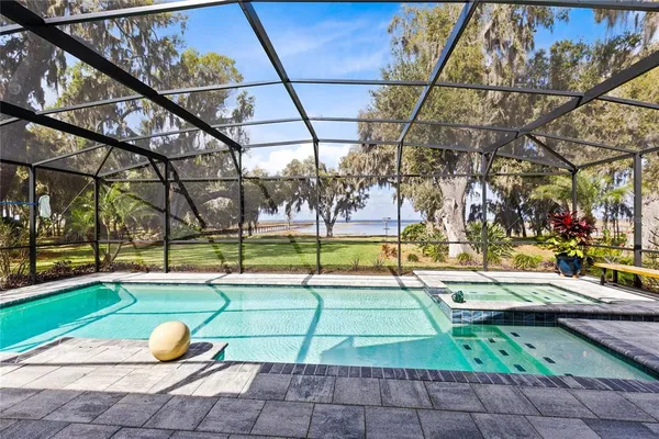 a view of a swimming pool with a patio and a yard